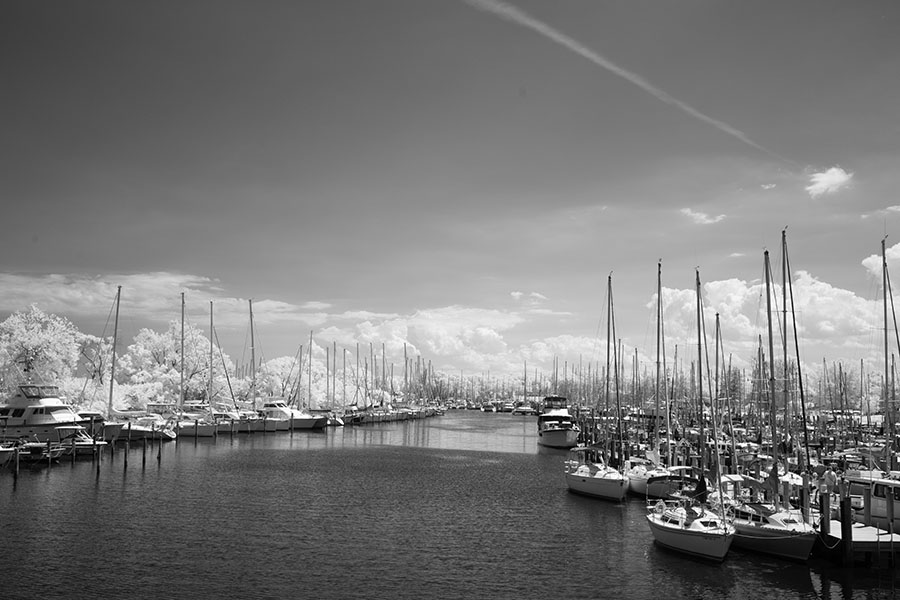 Infrared Photo of Small River with Many Pleasure Craft Docked on Either Side.